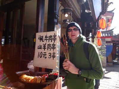 Jonny Blair trying barbecued food in Shuhe Old Town Yunnan China