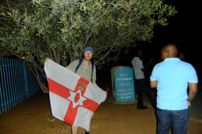 Jonny Blair and the travelling Northern Ireland flag in Botswana at Tlokweng