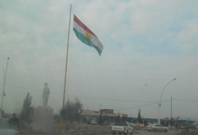 A statue and a Kurdish flag in Rabia.